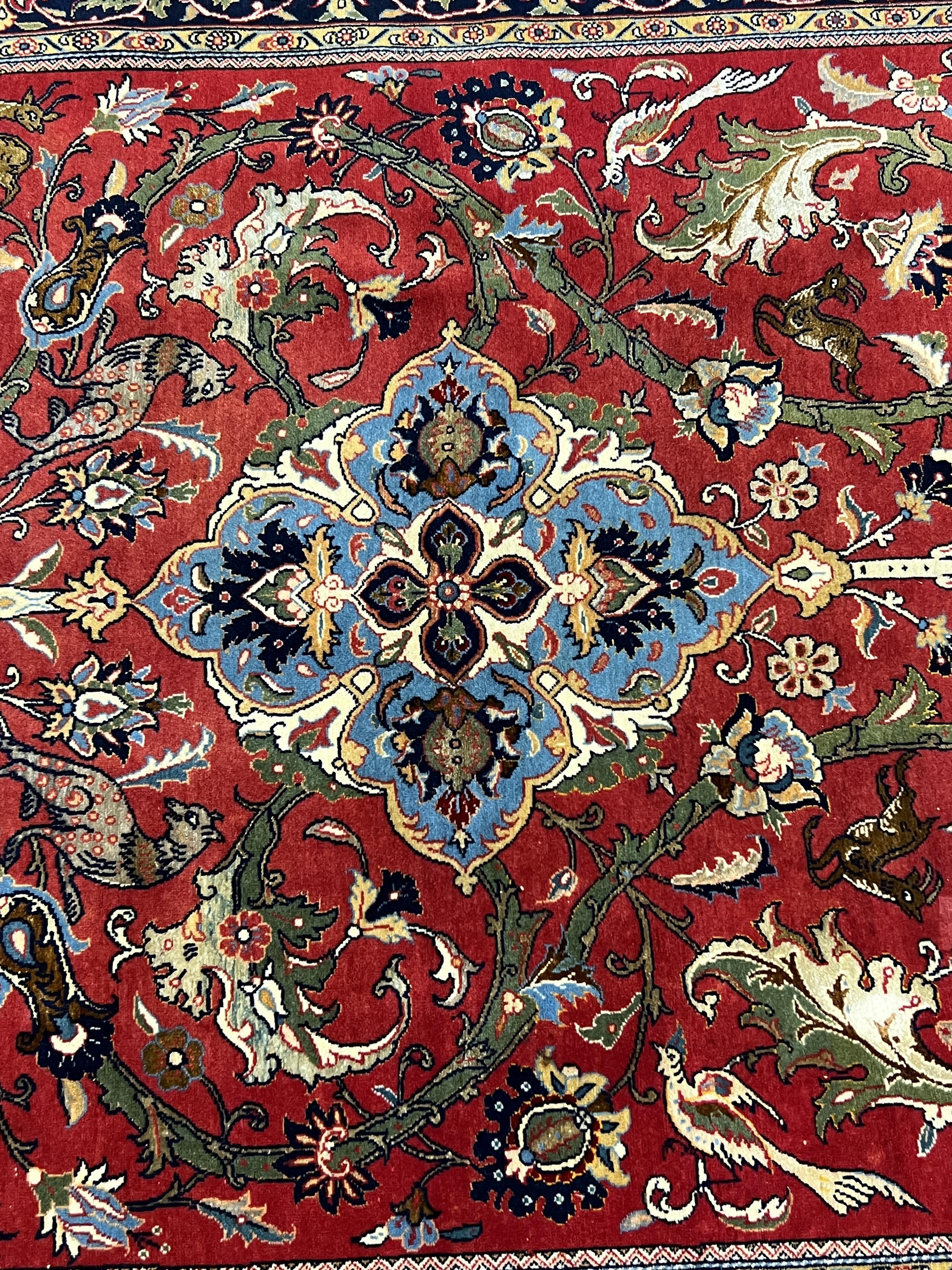 A Kashan red ground rug, woven with scrolling foliage and birds within a dark border, 216 x 138cm. Condition - good